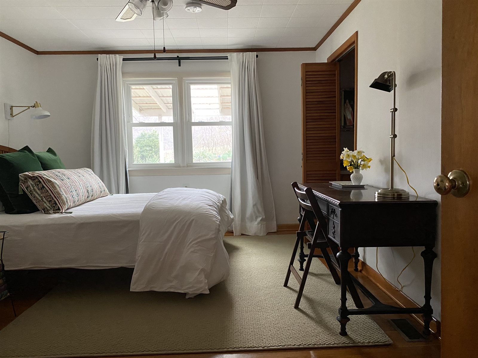 A serene bedroom with layered textiles and fresh daffodils